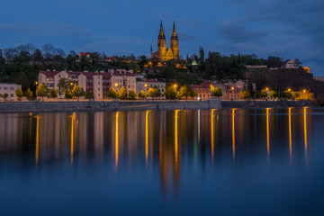 Fototapeta na wymiar Vysehrad with Basilica of St Peter and St Paul in Prague from Vltava riverside, Vysehrad, Czech Republic. Famous tourist destination beautiful lighted in the night.