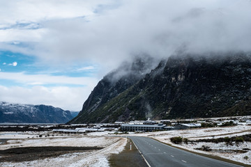 View of a road in Mount Cook Village covered with white fresh snow after a snowy day.
