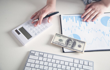 Business girl using calculator in his desk.