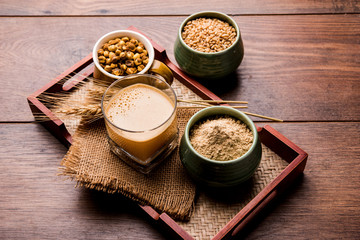 Sattu sharbat is a cooling sweet drink made in summer with roasted black chickpea flour, barley, suger, salt & water. served in a glass. selective focus