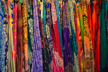 a large number of colorful shawls, patterned textiles, background