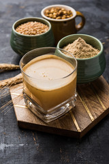 Sattu sharbat is a cooling sweet drink made in summer with roasted black chickpea flour, barley, suger, salt & water. served in a glass. selective focus