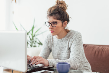 Young woman working at home. She is with her dogs