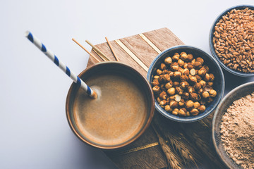 Sattu sharbat is a cooling sweet drink made in summer with roasted black chickpea flour, barley, suger, salt & water. served in a glass. selective focus