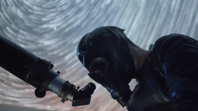 Creature alien man dressed in gas mask using telescope to spy on the night sky, strange wtf footage