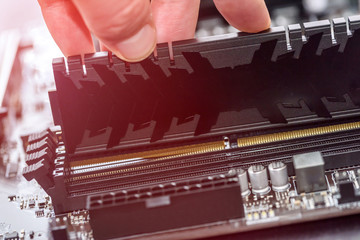 Male hand taking out ram memory on motherboard