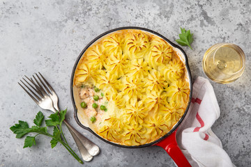 Salmon, mashed potatoes and vegetables casserole in enamel cast iron pan