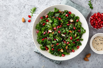 fresh kale, roasted chickpeas, almond and pomegranate salad in white bowl