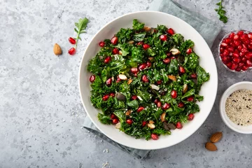 Deurstickers fresh kale, roasted chickpeas, almond and pomegranate salad in white bowl © anna_shepulova