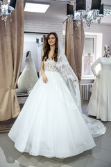 Young bride in charming wedding dress in boutique