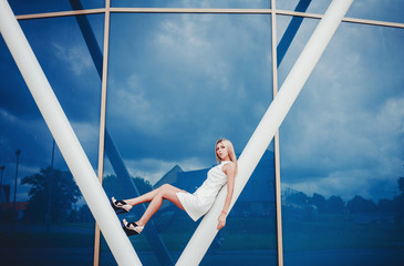 High fashion look. glamor stylish sexy beautiful young blond model girl in white dress on blue...