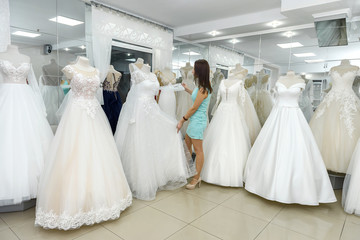 Bride choosing amazing wedding dress on a mannequin