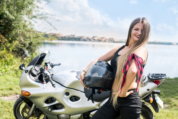 Naklejka na ściany i meble Young and happy woman on motorbike posing outdoors