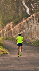 Man jogging on a downhill / uphill in suburb mountain road.