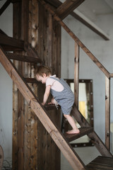 boy climbs the wooden stairs in casual interior