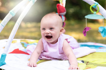 Portrait of cute smiling baby girl, outdoors, light effect