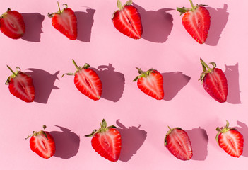 pink background with many fresh Strawberry halves