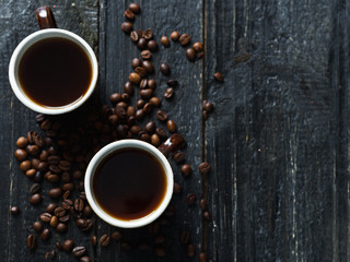 a mug of coffee beans and espresso on a dark wooden table
