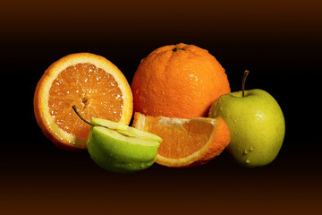 Apples and oranges fruits with drops and splashes of water on a black background