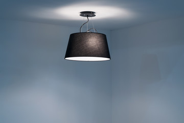 Modern Ceiling lamp hanging in the empty room.