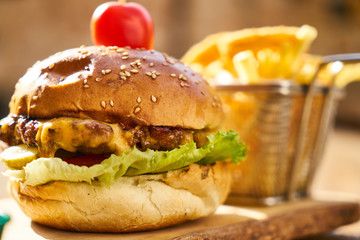 Cheeseburger with french fries on the wooden table