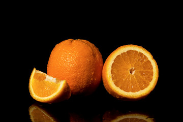 Oranges fruit with drops and splashes of water on a black background