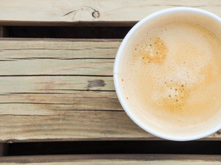 Cup of coffee to go on the wooden table. Street coffee, top view.