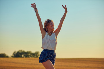 Fototapeta na wymiar Cute young woman jumping in a wheat field.