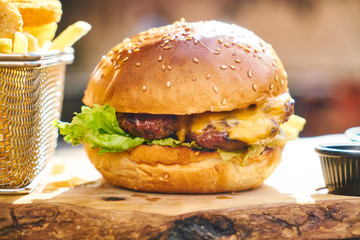 Cheeseburger with french fries on the wooden table