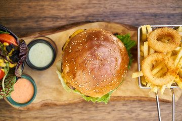 Cheeseburger with french fries on the wooden table