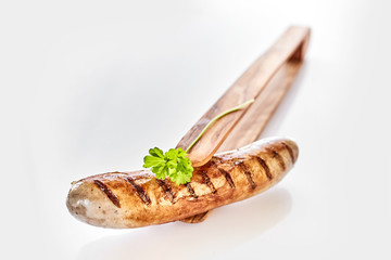 Single grilled pork sausage presented with thongs