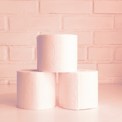 Stack of toilet paper rolls. Concept of body care, disposables, paper hygienic products. Pink.