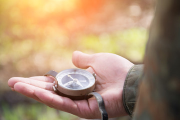 male hand holds a magnetic compass