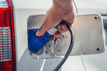 Close up on a charge port of electric car with plugged connector