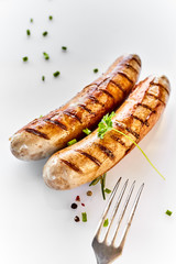 Two grilled sausages and a fork in close-up