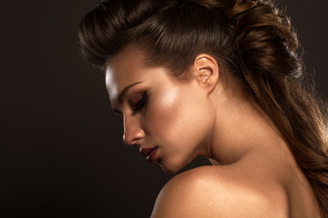 Fashion studio photo of gorgeous sensual woman with dark hair and bright glow make up.