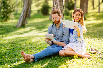 Lovely university students studying outdoors in park