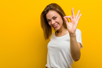 Young natural caucasian woman cheerful and confident showing ok gesture.