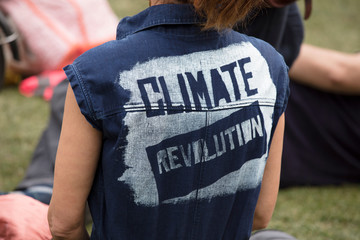 A climate change protestor wearing a top with climate revolution painted on