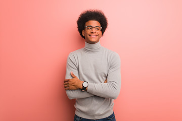 Young african american man over a pink wall smiling confident and crossing arms, looking up