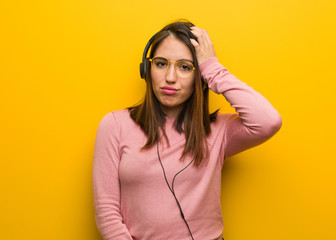 Fototapeta premium Young cute woman listening to music worried and overwhelmed