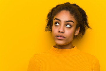 Young black woman closeup over an orange wall