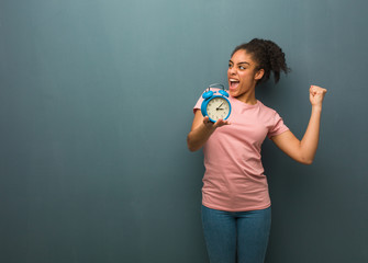 Young black woman who does not surrender. She is holding an alarm clock.