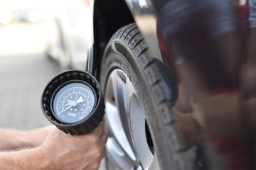 auto mechanic checks the air pressure of a tire in the garage