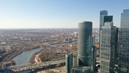 Obraz premium Aerial view of Moscow city glass skyscrapers and Moscow river. Cars driving on the motorway. Sunny, blue sky, spring. Russia. Modern. Urban.