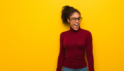 Young black african american girl with blue eyes winking, funny, friendly and carefree gesture