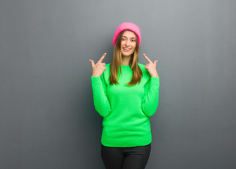 Naklejka premium Young natural russian girl smiles, pointing mouth