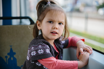 Baby girl commuting by tram at window seat