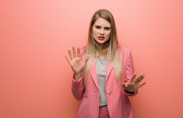 Young russian woman wearing pajama rejecting something doing a gesture of disgust