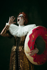 Adventures can't wait. Medieval redhead young woman in golden vintage clothing as a duchess...